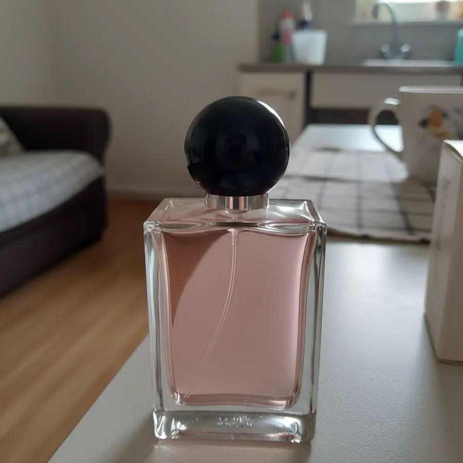Frasco de perfume sem marca fotografado com o celular, em casa